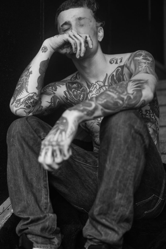Smoking tattooed male model in the stairwell