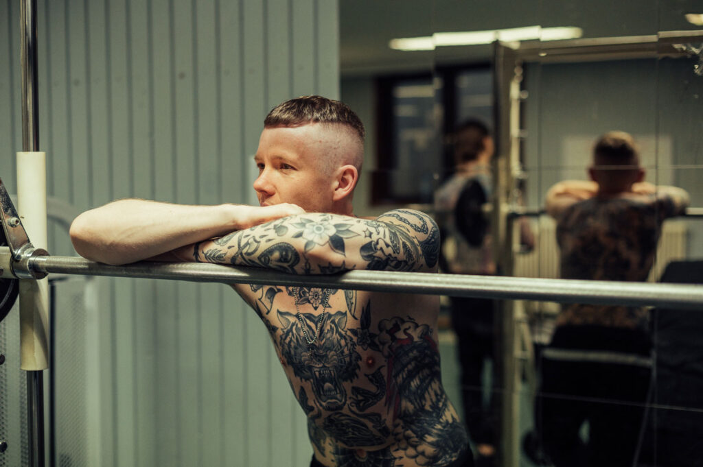 Männliches tätowiertes athletisches Model in Fitnessstudio